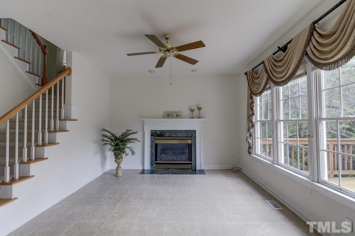 7913 Mayapple Place Raleigh, NC 27613 - Photo 6 of 20 a view of an empty room with stairs and a fireplace