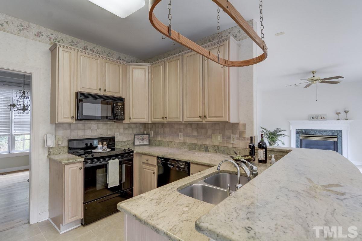 7913 Mayapple Place Raleigh, NC 27613 - Photo 7 of 20 a kitchen with granite countertop a sink stainless steel appliances and cabinets