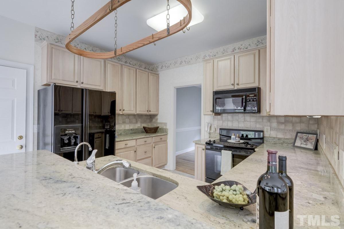 7913 Mayapple Place Raleigh, NC 27613 - Photo 8 of 20 a kitchen with a sink a stove and cabinets