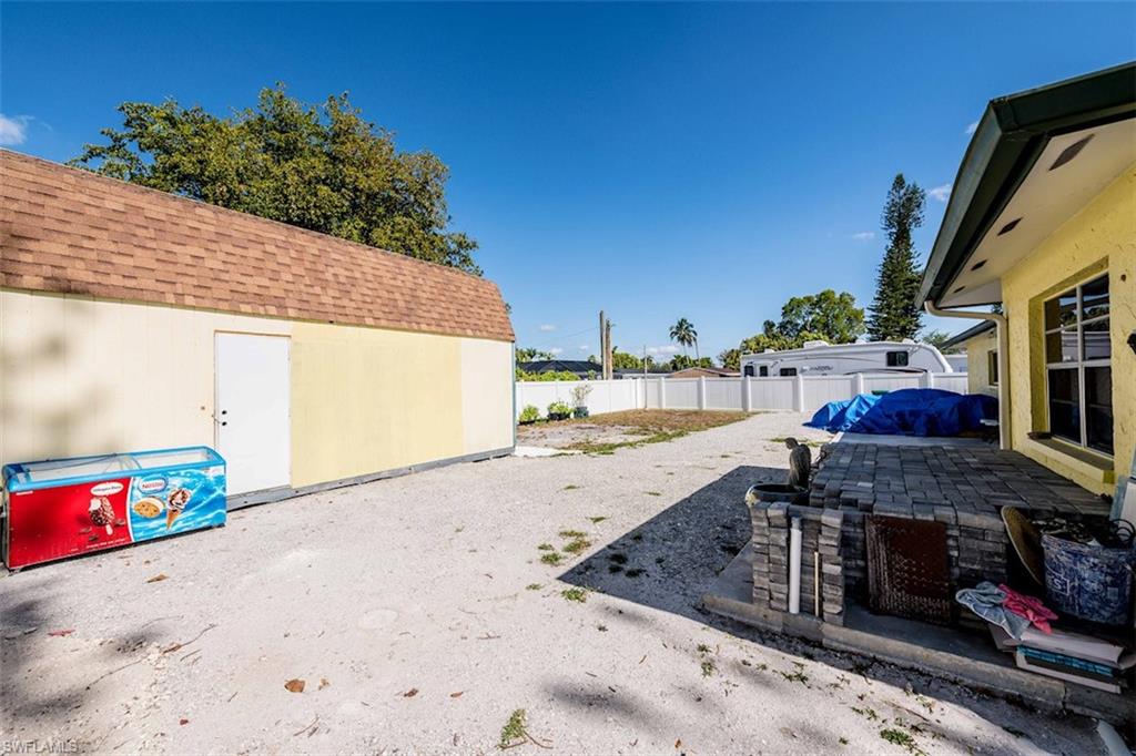 2137 44th Street Southwest Naples, FL 34116 - Photo 46 of 50 View of yard featuring a patio, a fenced backyard, and an outdoor structure