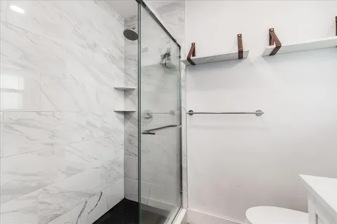 a bathroom with a granite countertop shower and a sink