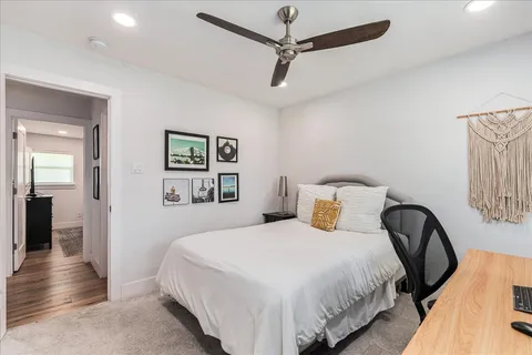 a bedroom with a bed and painting on the wall