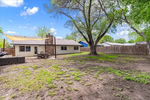 a view of a house with backyard and tree