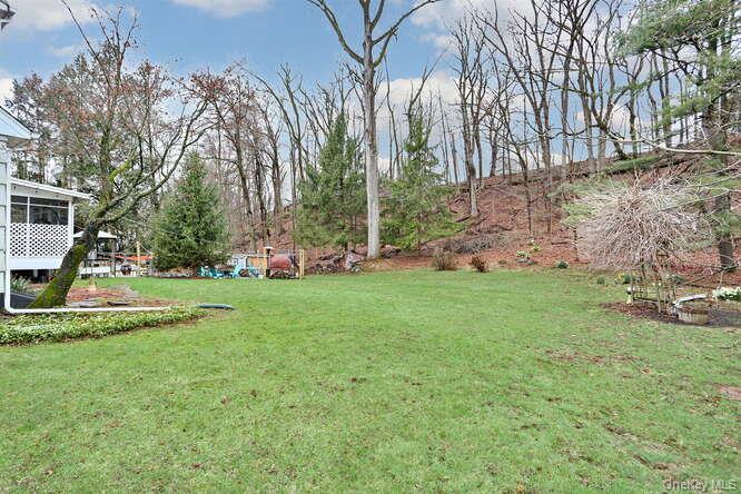 161 McNamara Road Spring Valley, NY 10977 - Photo 37 of 38 a view of a white house in front of a big yard with plants and large trees