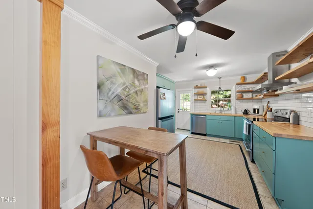 a kitchen with stainless steel appliances kitchen island granite countertop a table chairs sink and cabinets