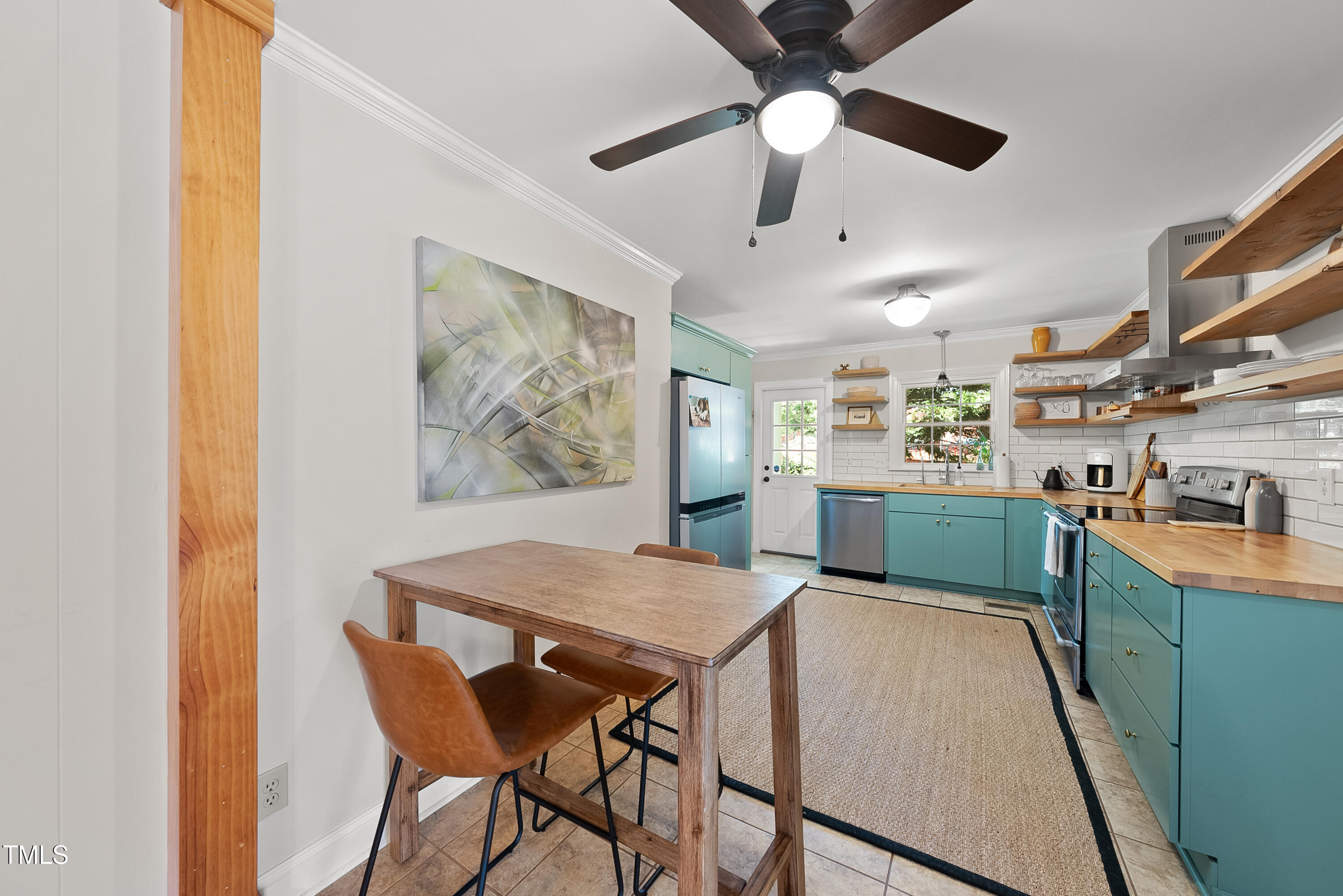 3116 Carovel Court Raleigh, NC 27612 - Photo 11 of 25 a kitchen with stainless steel appliances kitchen island granite countertop a table chairs sink and cabinets