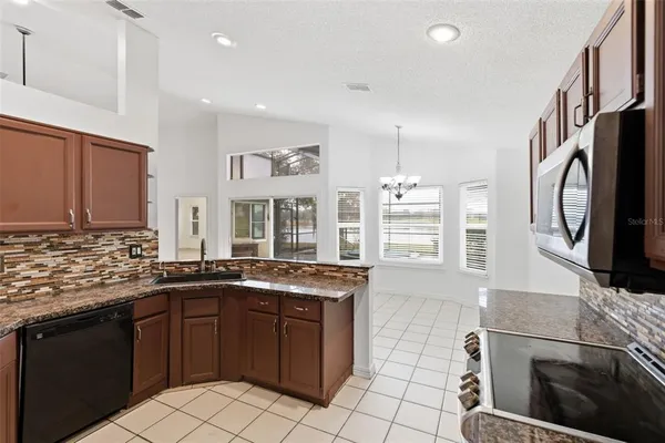 a kitchen with stainless steel appliances granite countertop a stove a sink and a refrigerator