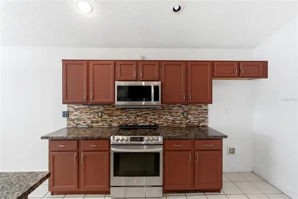 a kitchen with stainless steel appliances granite countertop a sink and a stove