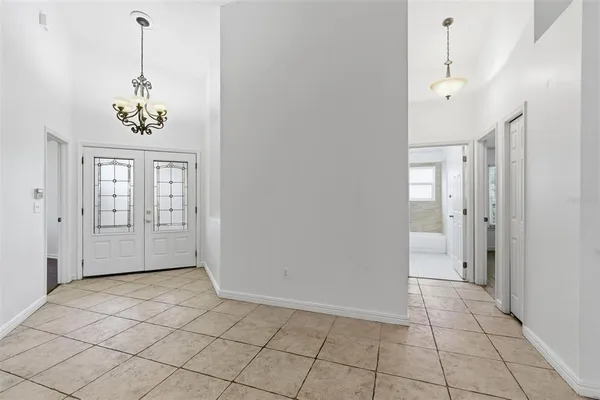 a bedroom with a bed a chandelier and mirror