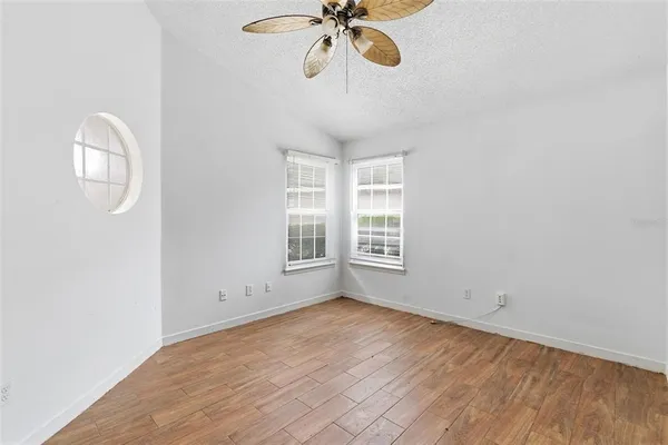 an empty room with a window and a fan