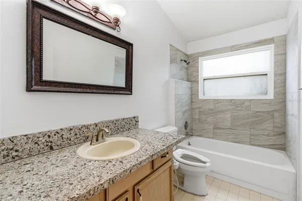 an empty room with wooden floor chandelier and window