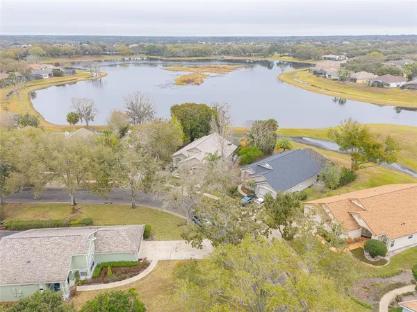 an aerial view of residential houses with outdoor space and lake view