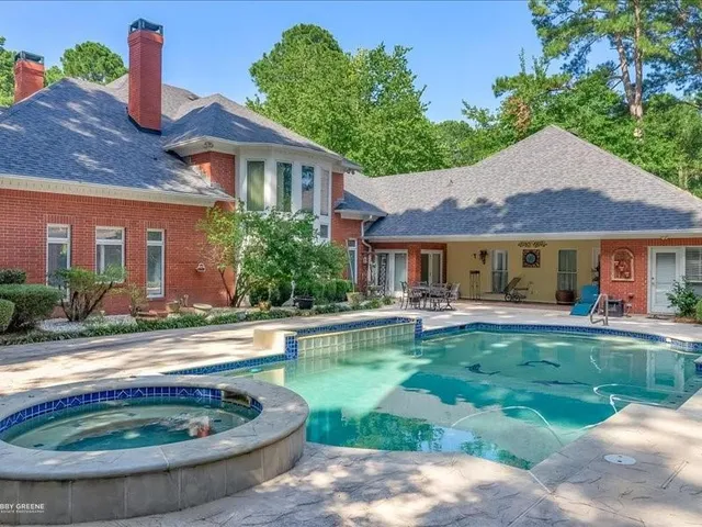 a view of a house with swimming pool and a yard