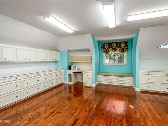 a view of a bedroom with wooden floor closet and windows
