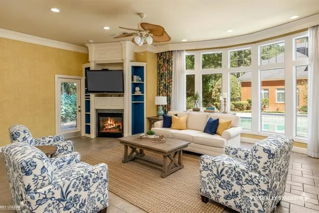 a living room with furniture large window and a fireplace