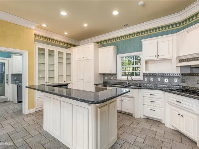 a kitchen with granite countertop a sink and cabinets