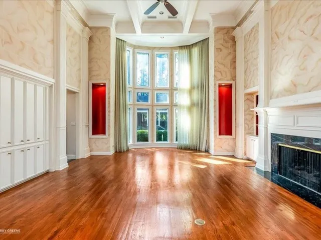 a view of an empty room with exposed radiator and fireplace