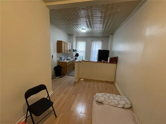 a view of a hallway with wooden floor and a living room