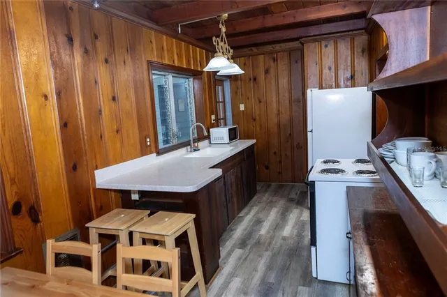 a kitchen with sink a refrigerator and wooden cabinets