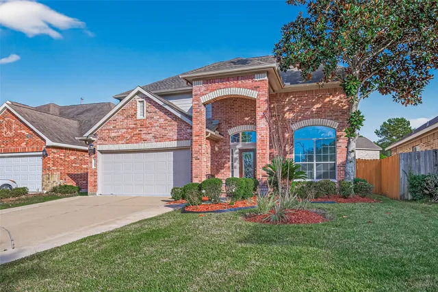 a front view of a house with a garden and plants