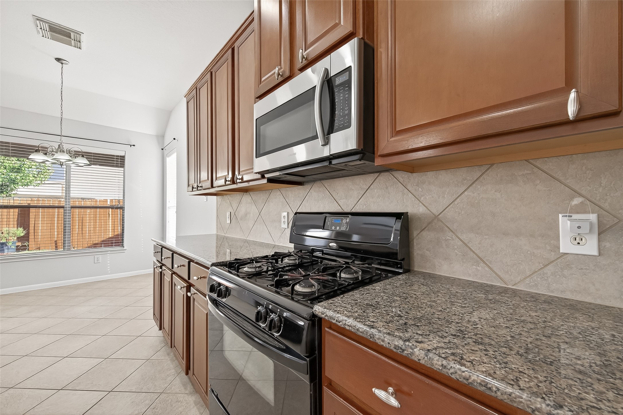 5103 Azalea Meadow Lane Katy, TX 77494 - Photo 11 of 34 a kitchen with stainless steel appliances granite countertop a stove a microwave and a sink