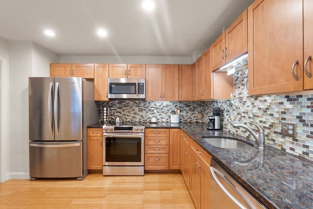 160 Pine Street, Unit 27 Newton, MA 02466 - Photo 5 of 30 a kitchen with stainless steel appliances granite countertop a sink stove and refrigerator