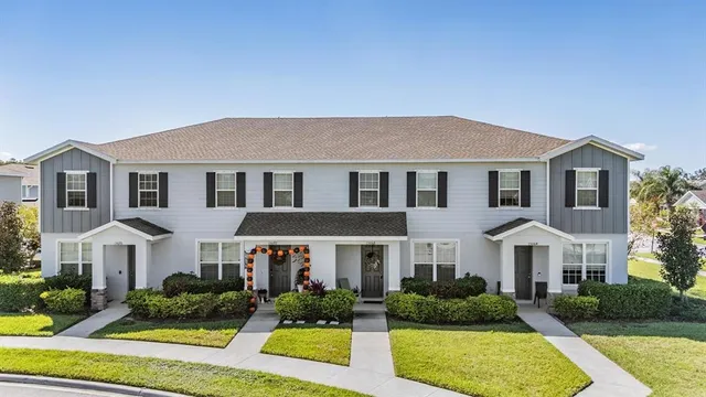 a front view of a residential houses with yard and green space