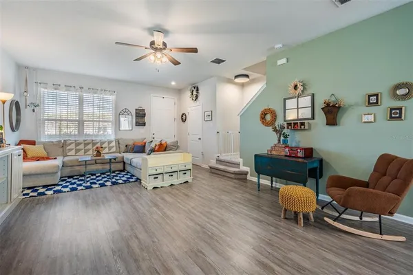 a living room with furniture and a wooden floor