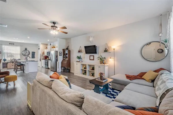 a living room with furniture a flat screen tv and kitchen view
