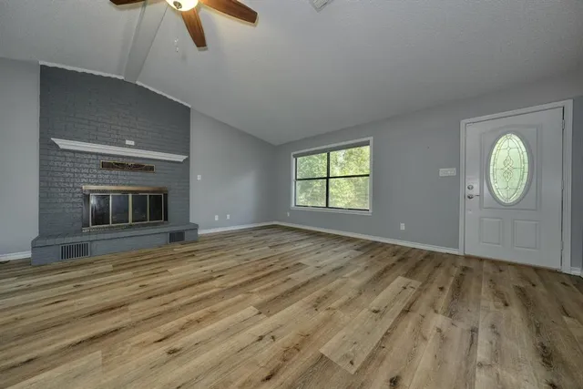 an empty room with windows and fireplace