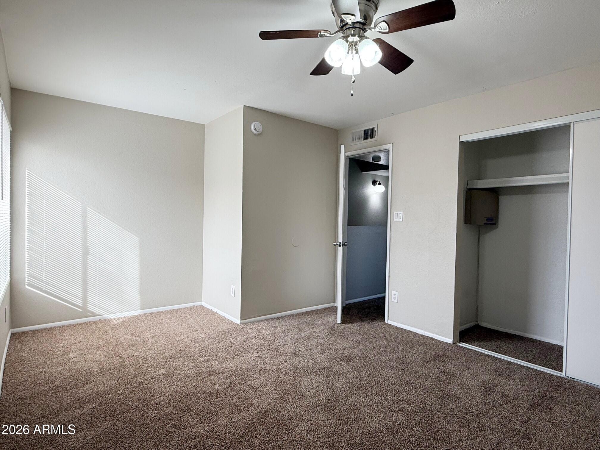 3840 North 43rd Avenue, Unit 34 Phoenix, AZ 85031 - Photo 11 of 18 a view of an empty room with a ceiling fan