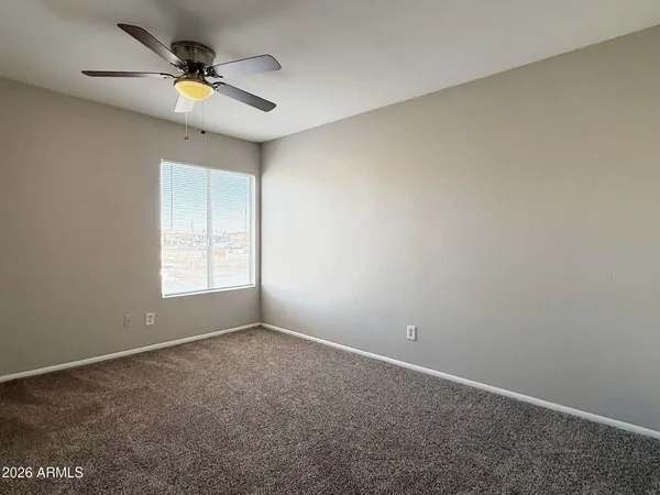 an empty room with closet and fan