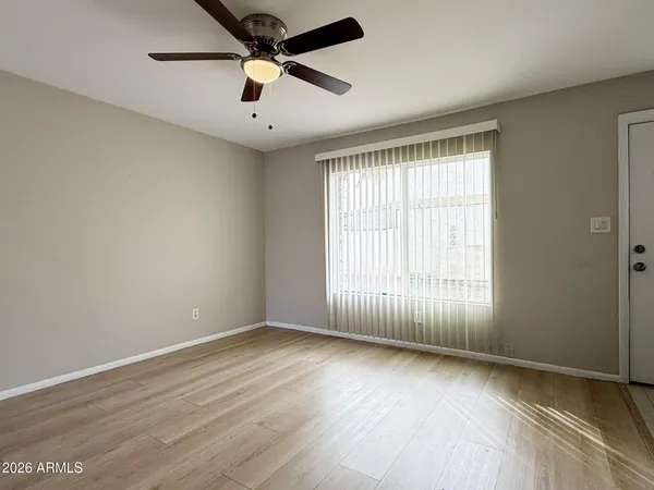 an empty room with wooden floor and windows