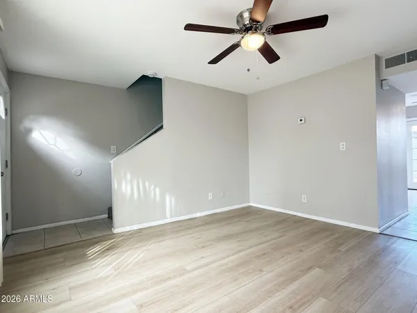 an empty room with fan and windows