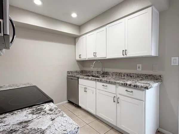a bathroom with a granite countertop sink and cabinets