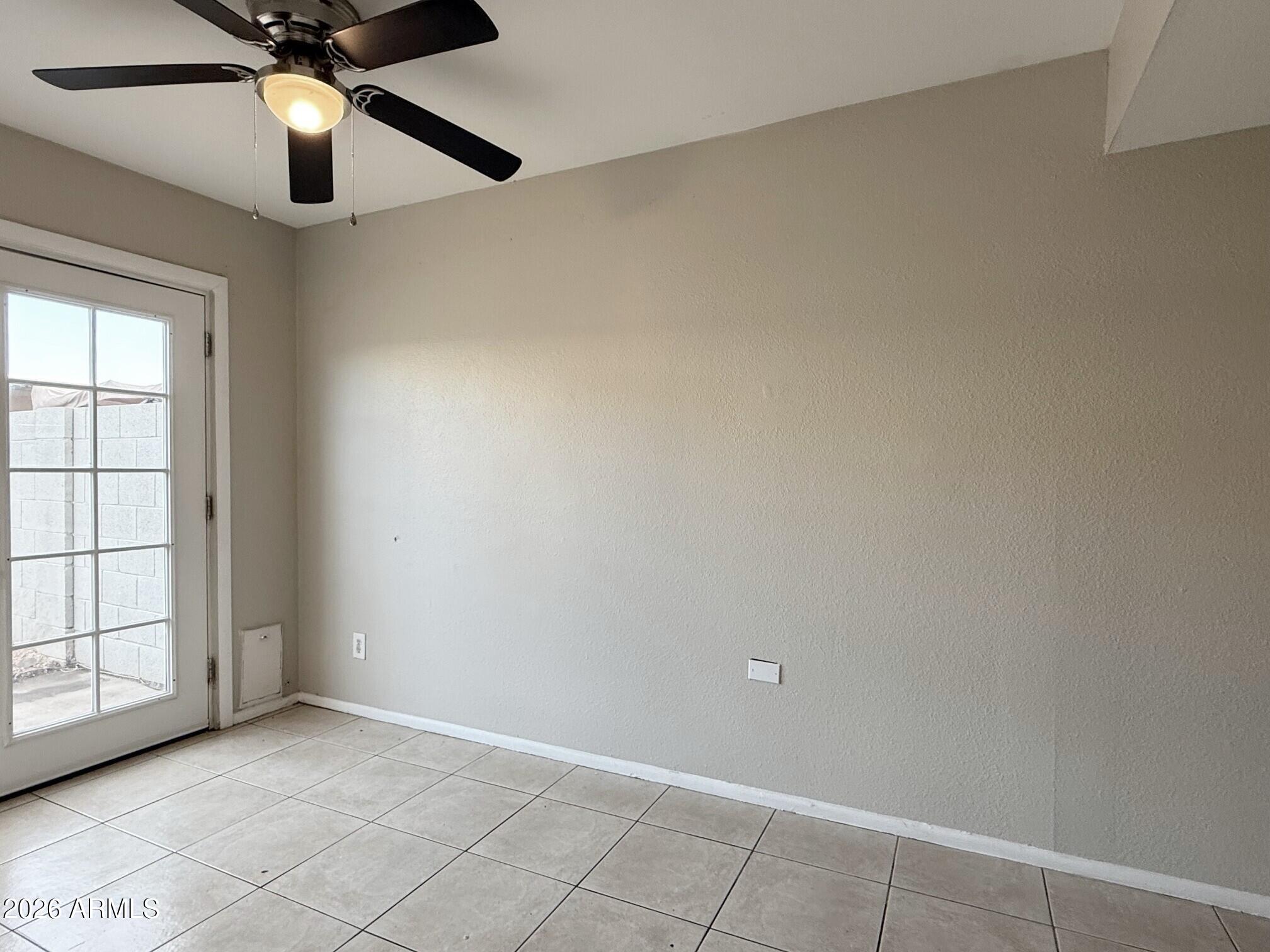 3840 North 43rd Avenue, Unit 34 Phoenix, AZ 85031 - Photo 8 of 18 an empty room with chandelier fan