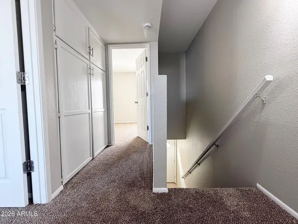 an empty room with a chandelier fan and windows