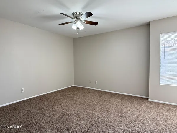 a view of an empty room with a ceiling fan