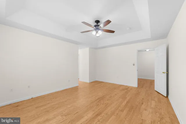 a view of a big room with wooden floor and a chandelier fan