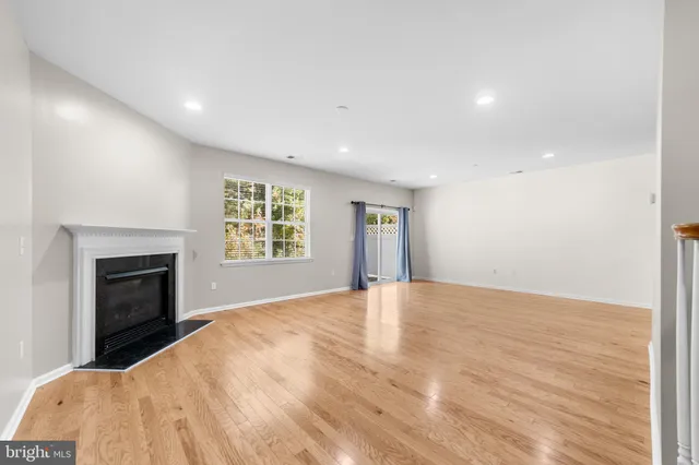 a view of empty room with a fireplace and wooden floor