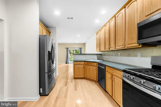 a kitchen with stainless steel appliances granite countertop a refrigerator and a stove top oven