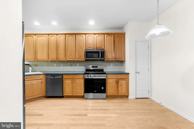 a kitchen with stainless steel appliances granite countertop a stove a sink and a microwave