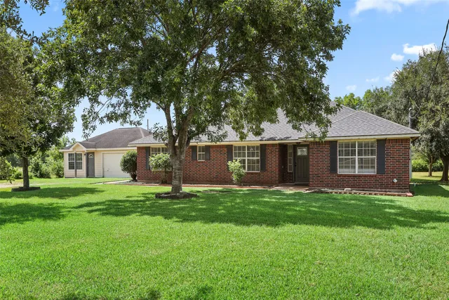 a front view of a house with a yard and trees