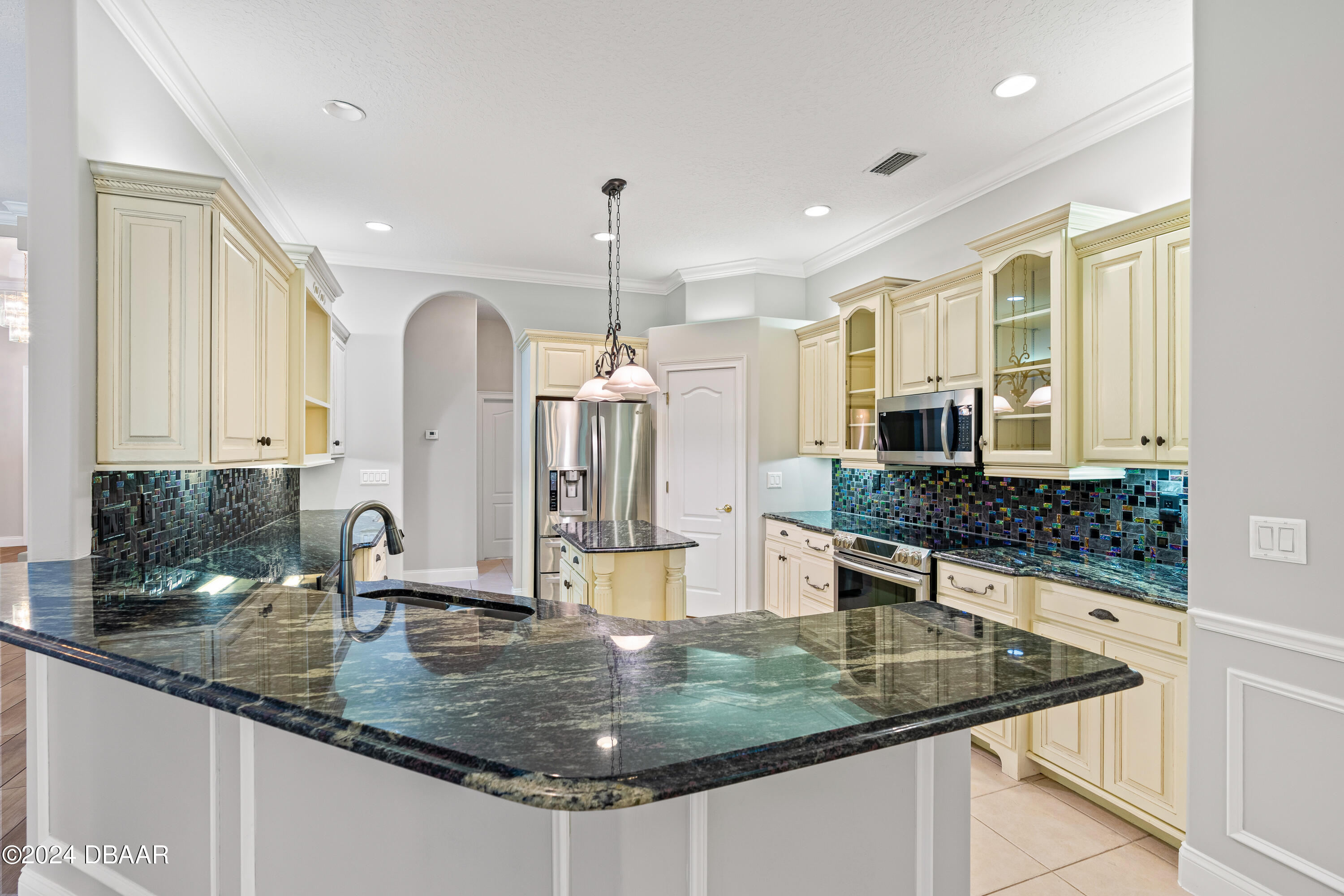16 Foxcroft Ormond Beach Ormond Beach, FL 32174 - Photo 11 of 54 a kitchen with stainless steel appliances granite countertop a sink a stove and a wooden cabinets
