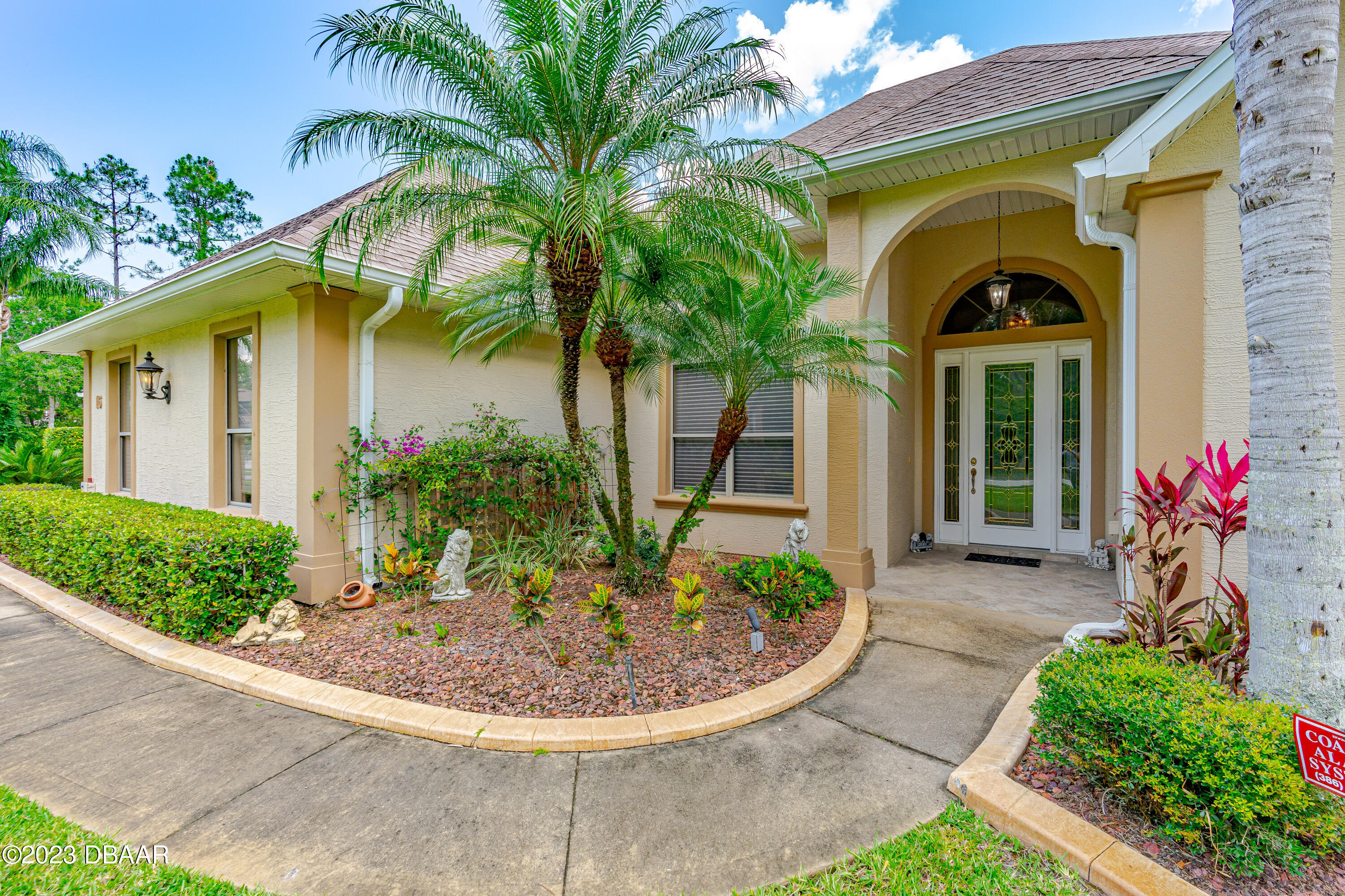 16 Foxcroft Ormond Beach Ormond Beach, FL 32174 - Photo 42 of 54 a view of a house with a small yard plants and palm trees