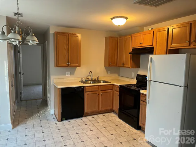 a kitchen with a refrigerator sink and cabinets