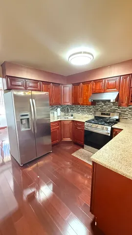 a kitchen with stainless steel appliances granite countertop a stove a sink and a refrigerator
