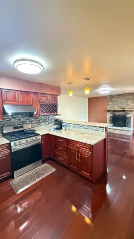 a kitchen with stainless steel appliances granite countertop a stove a sink and a oven