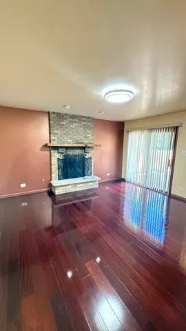a view of empty room with wooden floor and fireplace