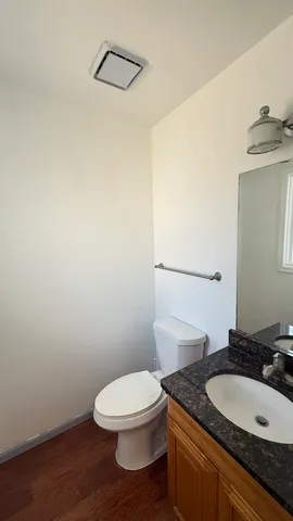 a bathroom with a granite countertop toilet a sink and a mirror
